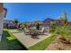 Spacious backyard featuring a dining set, water feature, lush artificial grass, and manicured landscaping at 2579 Speyburn Ave, Henderson, NV 89044