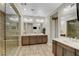 Bathroom featuring dual sinks and a stone-tiled shower with a glass door at 2579 Speyburn Ave, Henderson, NV 89044