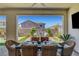 Welcoming covered patio with a dining area and outdoor TV overlooking the landscaped backyard at 2579 Speyburn Ave, Henderson, NV 89044