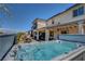 Inviting backyard showcasing a luxurious hot tub, complemented by comfortable seating and outdoor dining area at 2579 Speyburn Ave, Henderson, NV 89044