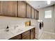 Well-lit laundry room features wood cabinets, white countertop, sink, and modern washer and dryer at 2579 Speyburn Ave, Henderson, NV 89044