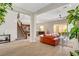 Spacious living room with tile floors, a staircase, and a modern orange sofa at 2579 Speyburn Ave, Henderson, NV 89044