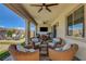 Inviting covered patio with wicker seating, a ceiling fan, and a view of the beautifully landscaped backyard at 2579 Speyburn Ave, Henderson, NV 89044