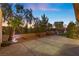 Large stone patio perfect for entertaining with mature landscaping and wrought iron fence at 2717 Mona Lisa St, Henderson, NV 89044