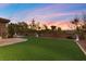 Backyard featuring synthetic grass, beautiful landscaping, and views of the sunset at 2717 Mona Lisa St, Henderson, NV 89044