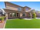 Backyard featuring well-maintained artificial turf, stone accents, patio, and an outdoor living space at 2717 Mona Lisa St, Henderson, NV 89044