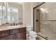 Bathroom with granite countertop, dark wood cabinets, glass enclosed shower and tile surround at 2717 Mona Lisa St, Henderson, NV 89044