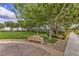 Green community space with a sidewalk, bench, and trees for shading on a sunny day at 2717 Mona Lisa St, Henderson, NV 89044