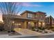 Beautiful two-story home featuring stone accents, desert landscaping, a porte-cochere, and a well-lit entrance at 2717 Mona Lisa St, Henderson, NV 89044