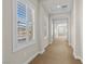 A bright hallway is lined with windows featuring white shutters and plush carpet flooring at 2717 Mona Lisa St, Henderson, NV 89044