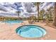 Inviting hot tub adjacent to the pool with cabanas, chairs, and manicured landscaping at 2717 Mona Lisa St, Henderson, NV 89044