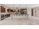 Spacious kitchen with dark wood cabinetry, granite countertops, stainless steel appliances, and an island with bar seating at 2717 Mona Lisa St, Henderson, NV 89044