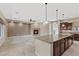 Open concept kitchen and living room featuring stone floors, pendant lighting, and a fireplace at 2717 Mona Lisa St, Henderson, NV 89044