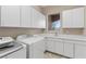 A well-organized laundry room with ample cabinet space, a sink, and modern washer and dryer at 2717 Mona Lisa St, Henderson, NV 89044