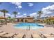 Resort-style pool area with sun loungers, cabanas, palm trees, and a clubhouse for relaxing and entertaining guests at 2717 Mona Lisa St, Henderson, NV 89044