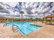 Large swimming pool with lounge chairs, cabanas, and mature landscaping at 2717 Mona Lisa St, Henderson, NV 89044