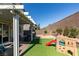 Backyard with a covered patio, synthetic grass, and a play structure at 2928 Sunday Silence Rd, North Las Vegas, NV 89086