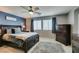 Well-lit bedroom features a ceiling fan, a large bed with nightstands, and a dresser at 2928 Sunday Silence Rd, North Las Vegas, NV 89086