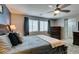 Bedroom featuring a ceiling fan, a bed with nightstands, and a dresser next to the bathroom entrance at 2928 Sunday Silence Rd, North Las Vegas, NV 89086