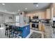 Open kitchen featuring stainless steel appliances, granite countertops, and a blue island with barstool seating at 2928 Sunday Silence Rd, North Las Vegas, NV 89086