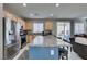 Modern kitchen features a large island with granite countertops, stainless steel refrigerator, and view of the backyard at 2928 Sunday Silence Rd, North Las Vegas, NV 89086