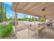 Outdoor living on covered patio with daybed and table, set against landscape backdrop at 3065 S Torrey Pines Dr, Las Vegas, NV 89146