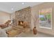 Cozy living room highlighting a stone fireplace, large window, and stylish decor, perfect for relaxation at 3065 S Torrey Pines Dr, Las Vegas, NV 89146