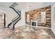 Spacious living room with staircase, wood-paneled wall, fireplace, and stone flooring at 3198 Stella Cilento Ave, Henderson, NV 89044