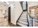 Elegant staircase with wood steps, black handrail, and decorative wall paneling at 3198 Stella Cilento Ave, Henderson, NV 89044