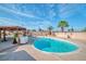 Inviting backyard with a sparkling private swimming pool, mature palms, and patio area at 3558 Wayne Cir, Las Vegas, NV 89121