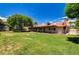 Expansive backyard with lush lawn, mature trees, a covered patio, and a storage shed at 3753 S Rosecrest Cir, Las Vegas, NV 89121