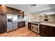 Modern kitchen with stainless steel appliances, granite countertops, dark wood cabinets, and a breakfast bar at 3753 S Rosecrest Cir, Las Vegas, NV 89121