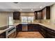 Kitchen with stainless steel appliances, granite countertops, dark wood cabinets and tile backsplash at 3753 S Rosecrest Cir, Las Vegas, NV 89121