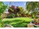 This yard offers a vibrant green lawn, complemented by tasteful flower beds and mature trees at 4017 Kristina Lynn Ave, North Las Vegas, NV 89081