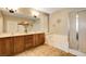 Bathroom showcasing double vanity, soaking tub, glass shower, tile flooring and shuttered window at 4017 Kristina Lynn Ave, North Las Vegas, NV 89081