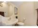 A half bathroom features a circular mirror, white sink, and a toilet at 4017 Kristina Lynn Ave, North Las Vegas, NV 89081