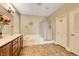 Bathroom showcasing double vanity, soaking tub, glass shower, tile flooring and shuttered window at 4017 Kristina Lynn Ave, North Las Vegas, NV 89081