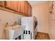 This laundry room has upper cabinets, a sink, and a stacked washer and dryer at 4017 Kristina Lynn Ave, North Las Vegas, NV 89081