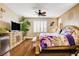 A well lit main bedroom features plantation shutters, ceiling fan, hardwood floors, and a mini fridge at 4017 Kristina Lynn Ave, North Las Vegas, NV 89081