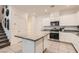 Bright kitchen featuring white cabinets, granite countertops, stainless steel appliances and a large island at 489 Filaree Pl, Henderson, NV 89015