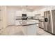 Bright kitchen featuring white cabinets, granite countertops, stainless steel appliances and a large island at 489 Filaree Pl, Henderson, NV 89015