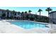 Relaxing pool area with clear water, surrounded by palm trees, lounge chairs and a community clubhouse at 489 Filaree Pl, Henderson, NV 89015