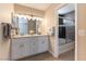 Bathroom featuring a double vanity with ample storage and a tiled shower with glass doors at 5005 Chambliss Dr, Las Vegas, NV 89130
