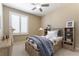 This bedroom features neutral walls and carpet, a ceiling fan, and a window with white shutters at 5005 Chambliss Dr, Las Vegas, NV 89130
