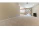 Bright living room features plush carpet, a brick fireplace, and access to the backyard at 5005 Chambliss Dr, Las Vegas, NV 89130