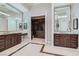 Bathroom featuring dual vanities, granite countertops, and a door leading to a custom walk-in closet at 5367 Secluded Brook Ct, Las Vegas, NV 89149