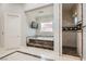 Luxurious bathroom with a marble step-up bathtub, walk-in shower, and tiled floors at 5367 Secluded Brook Ct, Las Vegas, NV 89149