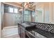 Modern bathroom featuring tub and shower combination with mosaic tile and dark wood vanity at 5367 Secluded Brook Ct, Las Vegas, NV 89149