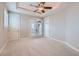 Bright bedroom featuring a tray ceiling, carpeted floors, and french doors with balcony access at 5367 Secluded Brook Ct, Las Vegas, NV 89149