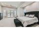 Spacious bedroom featuring a dark tufted headboard, carpeted floors, and french doors leading to the backyard at 5367 Secluded Brook Ct, Las Vegas, NV 89149